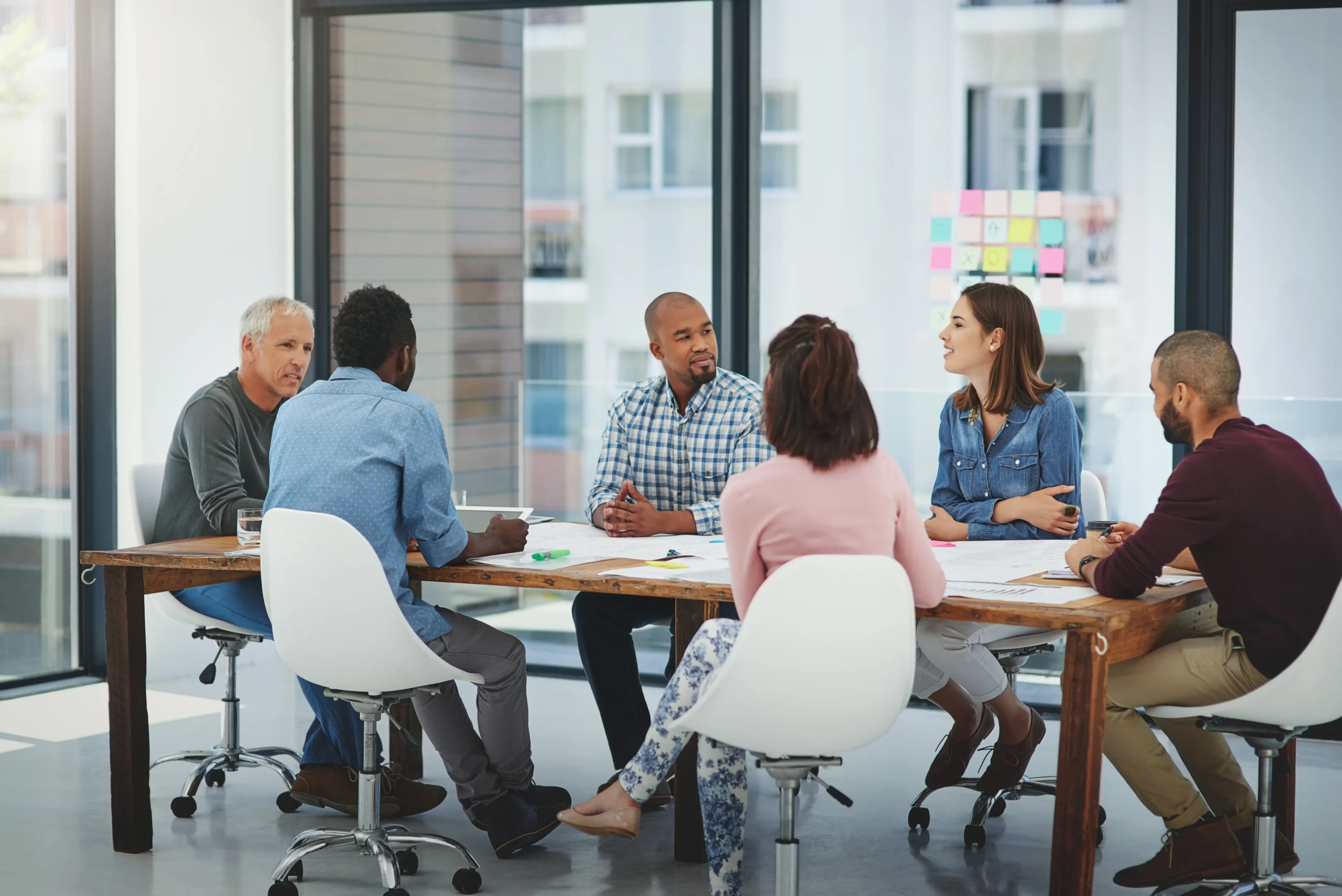 Business people, meeting and discussion with creative team for collaboration, planning or brainstorming at office. Group of employees talking in boardroom, conference or ideas in startup at workplace