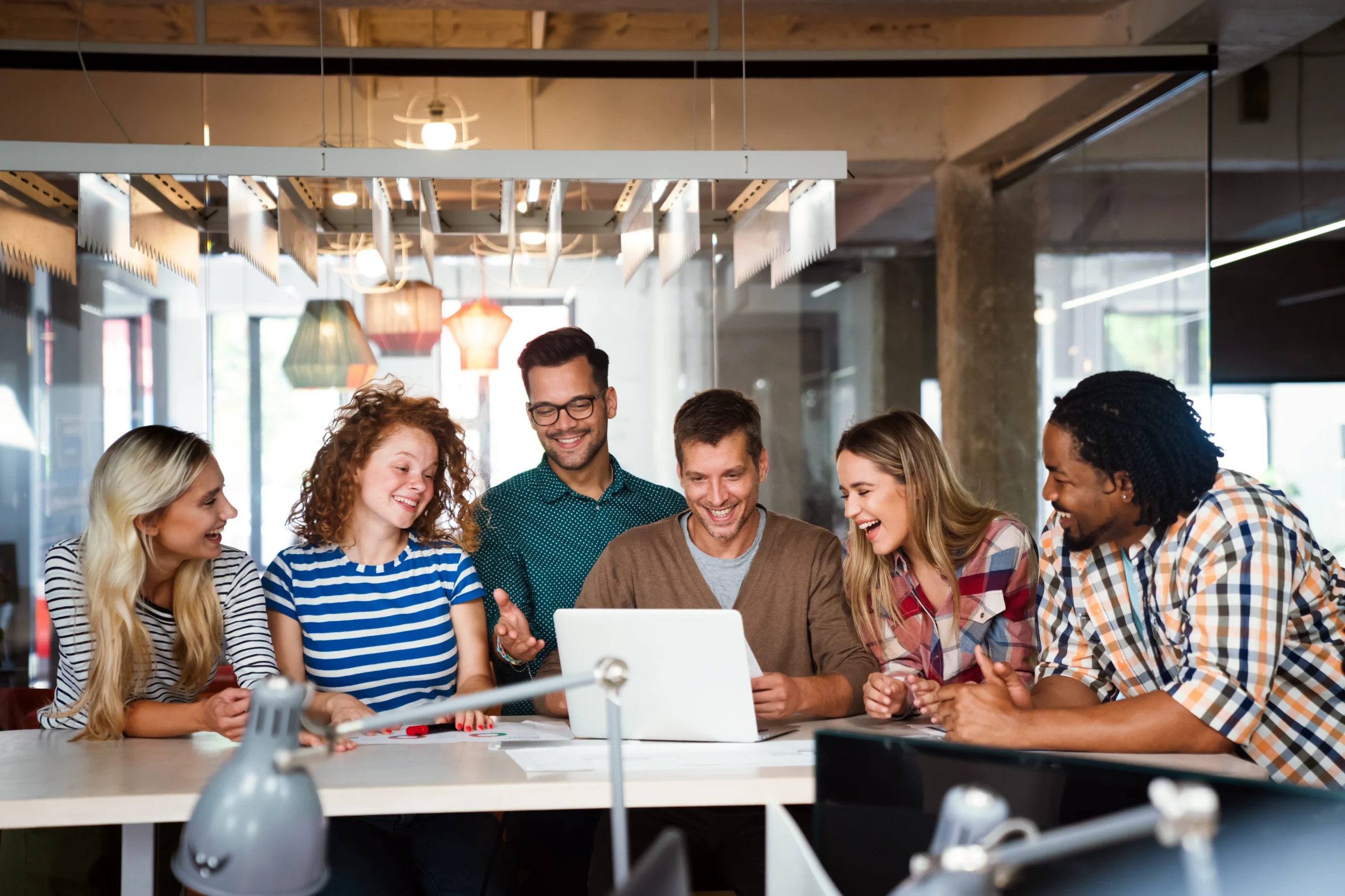 Smiling diverse colleagues gather in boardroom brainstorm discuss financial statistics together