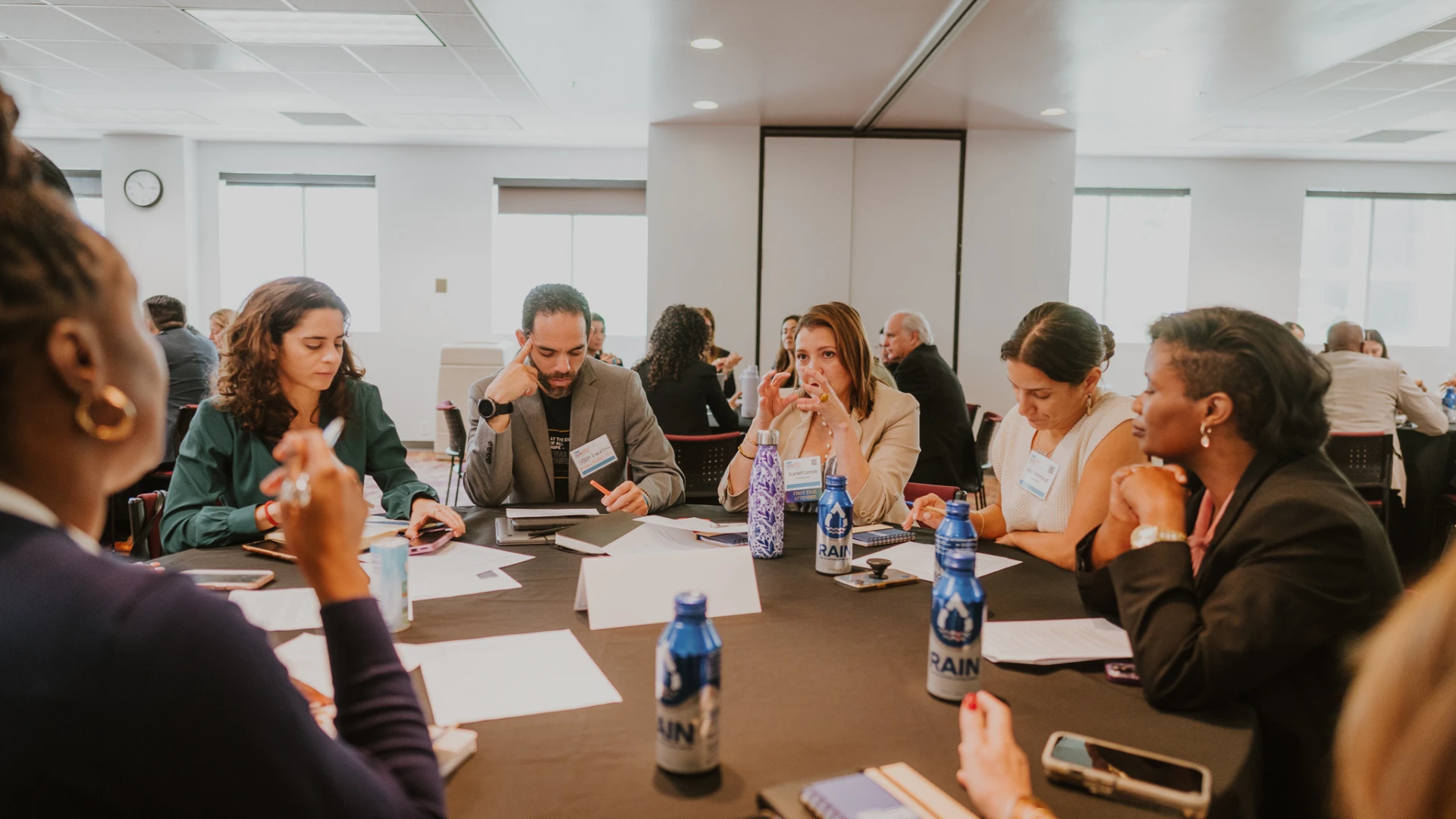 A group of professionals in discussion at a conference table, actively brainstorming and collaborating in a focused setting.